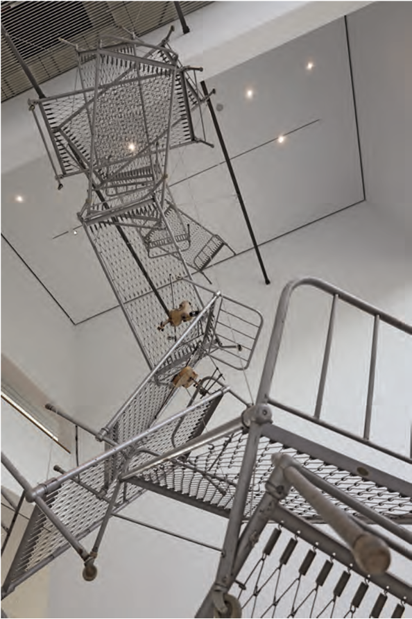 Hängende Metallbetten und Gitterplattformen in einer Galerie, von unten aufgenommen.